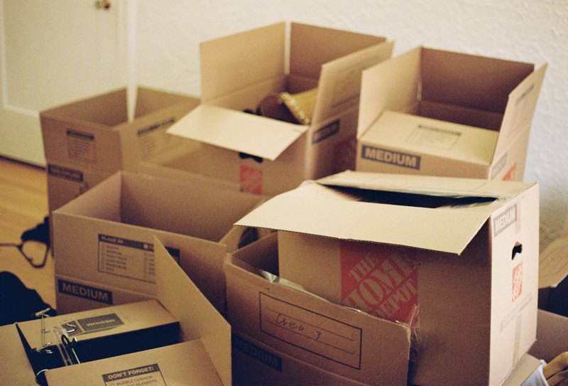 Open cardboard moving boxes spread across a room.