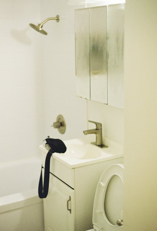 A camera rests on the sink in a softly lit bathroom.