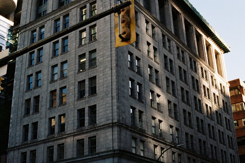 Late sunlight catches the corner of a stone building beneath a traffic signal.